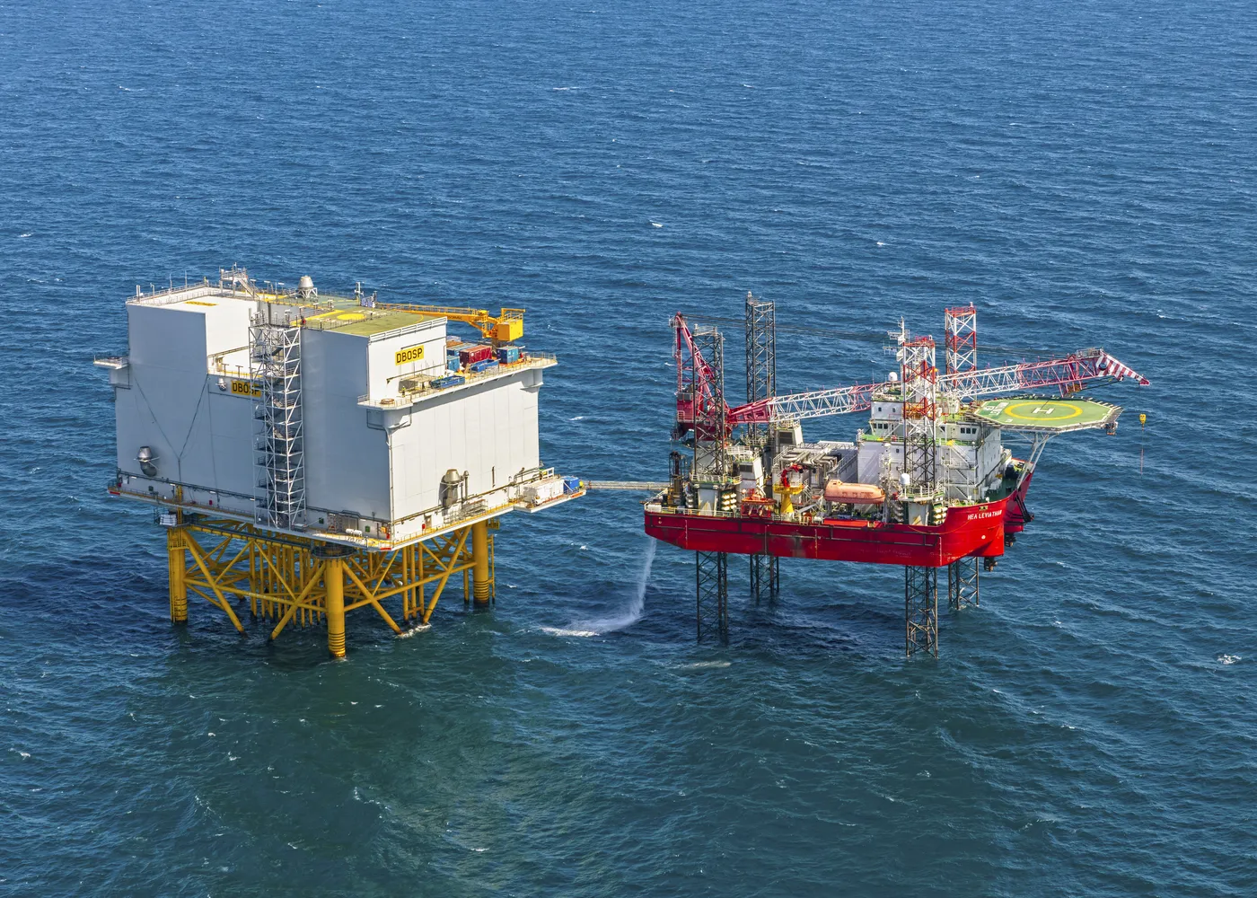 Self-elevating support vessel working alongside an offshore installation